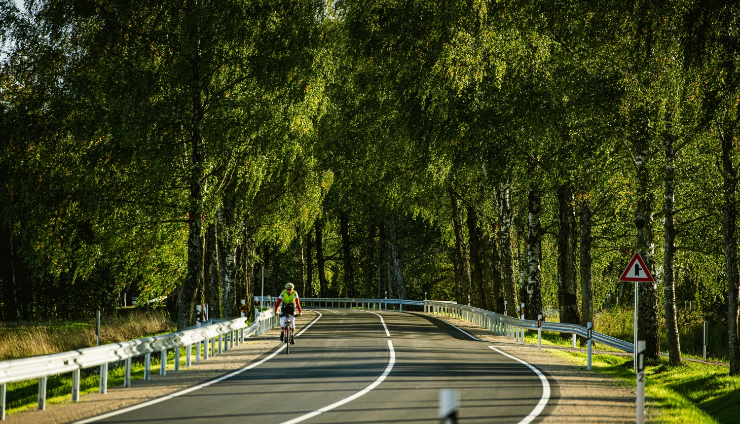 velosipēdists uz autoceļa vasaras dienā